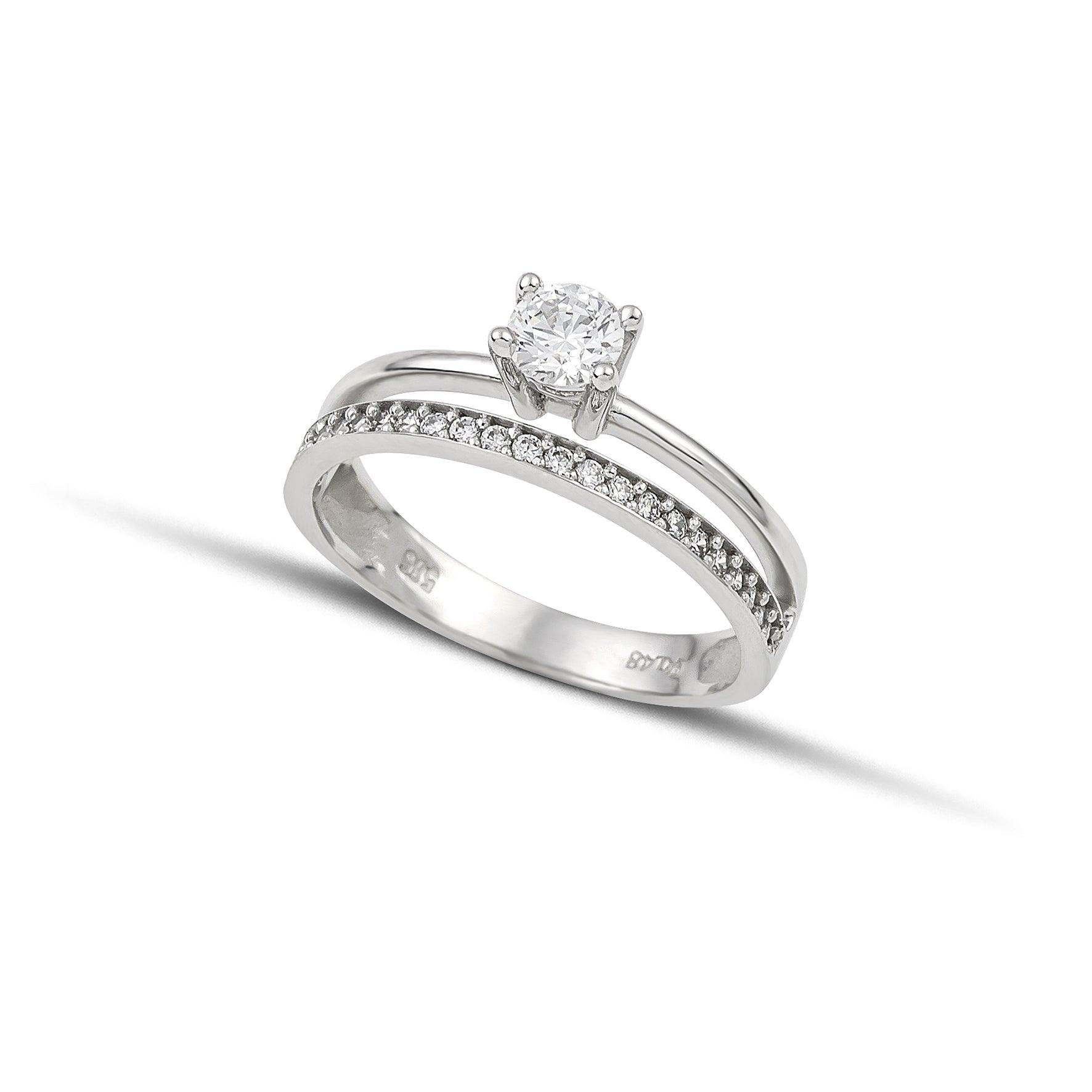 Μονόπετρο δαχτυλίδι γάμου με διαμάντι, που συνδυάζει ένα δαχτυλίδι σειρέ με διαμάντια δίνοντας την αίσθηση διπλού δαχτυλιδιού, κατασκευασμένο από λευκόχρυσο.