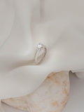 Mονόπετρο δαχτυλίδι με διαμάντι κατασκευασμένο από λευκόχρυσο με καστόνι σχήματος "V". 