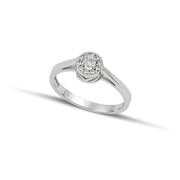 Μονόπετρο δαχτυλίδι ροζέτα με κεντρικό διαμάντι round cut και πέτρες από μικρότερα διαμάντια, κατασκευασμένο από λευκόχρυσο φορεμένο σε γυναικείο χέρι.
