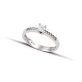 Mονόπετρο δαχτυλίδι με διαμάντι κατασκευασμένο από λευκόχρυσο με καστόνι σχήματος "V" και πλαϊνές πέτρες από μικρότερα διαμάντια.