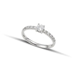 Μονόπετρο δαχτυλίδι με διαμάντι, κατασκευασμένο από λευκόχρυσο. πλαϊνές πέτρες από μικρότερα διαμάντια και καστόνι με τέσσερα δόντια.