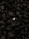 μονόπετρο δαχτυλίδι ροζέτα με κεντρικό διαμάντι σε σχήμα καρδιάς και πλαίνές πέτρες από μικρότερα διαμάντια, κατασκευασμένο από λευκόχρυσο.