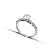 μονόπετρο δαχτυλίδι γάμου με κεντρική πέτρα από διαμάντι και πλαϊνές πέτρες κατασκευασμένο από λευκόχρυσο φορεμένο σε γυναικείο χέρι