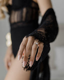λευκόχρυσο μονόπετρο με διαμάντι σχήματος φλόγας φορεμένο σε γυναικείο χέρι