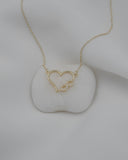 Χρυσό κολιέ Κ14 καρδιά με άπειρο και ζιργκόν σε λευκό φόντο.